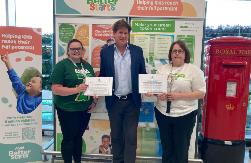 Alex is standing next to two women who are employees of ASDA. Each woman is holding a certificate celebrating the Parliamentary Motions lodged to recognise ASDA.