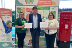 Alex is standing next to two women who are employees of ASDA. Each woman is holding a certificate celebrating the Parliamentary Motions lodged to recognise ASDA.