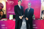 Alex and Marek standing in front of the CIPD booth at Holyrood.