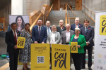 Alex and others from Holyrood posing on a staircase with Cancer Card signage.
