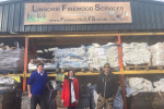 Alex stands in front of Linnorie Firewood Services with two of the Services' team members.
