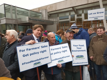 Alex holding a sign at the NFU Scotland rally.