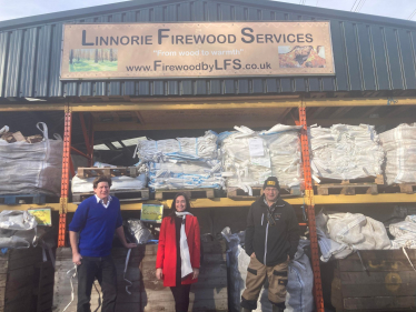 Alex stands in front of Linnorie Firewood Services with two of the Services' team members.